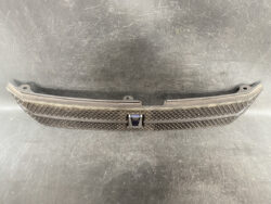 Front car grille with diamond mesh pattern and a centered Volvo emblem.