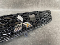 Glossy black honeycomb car grille with a chrome Mitsubishi emblem at the center.