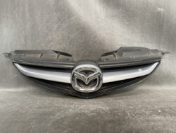 Mazda front grille with chrome emblem centered on black/silver trim (auto part).