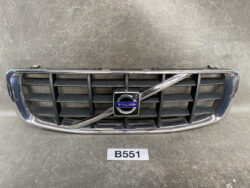 Front view of a Volvo car grille with a chrome frame and diagonal stripe, featuring the Volvo emblem in the center on a dark background.