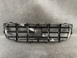 Black plastic car front grille with rectangular openings and a central mounting area for an emblem