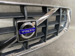 Close-up of a Volvo grille with the blue and silver Volvo emblem centered on chrome trim