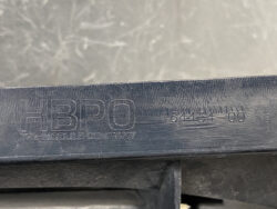 Close-up of a dark plastic surface with embossed text, including the phrase 'THE MODEL COMPANY' and the code '64434-00'.