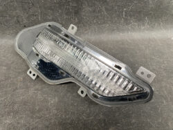 Automotive tail light assembly with a clear lens and multiple LED or reflector elements on a dark background