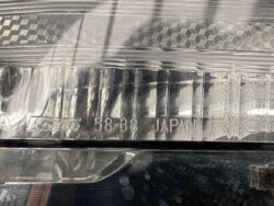 Close-up of a car headlight lens showing embossed KOITO branding and the text 58-38 JAPAN.