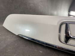 Close-up of a light gray car door panel with a chrome-trimmed handle.