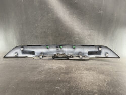 Rear interior of a car hatch/panel with latch mechanism and green mounting clips exposed.