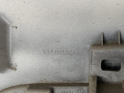 Close-up of a textured gray plastic car part stamped with 'HONDA' and 'ABS'