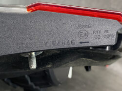 Close-up of a Stanley taillight housing with part number STANLEY W4846, an arrow, and an E4 certification mark.