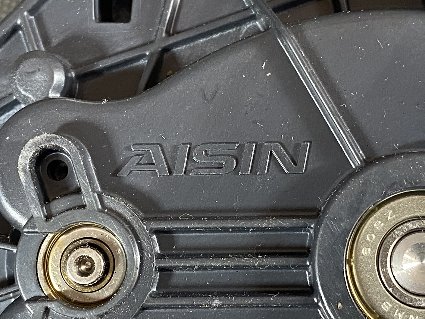 Suzuki Solio Mitsubishi Delica D:2 Genuine Power Slide Door Motor 79R0L Left Side 3 Close-up of a black plastic mechanical housing with the embossed brand 'ASIN' and two metal bearings on either side.