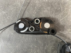 Suzuki Solio Mitsubishi Delica D:2 Genuine Power Slide Door Motor 79R0L Left Side 15 Close-up of a bicycle gear shifter component: black plastic housing with metal bushings and a taut cable running along the side.
