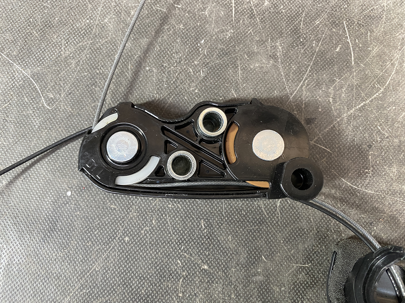 Suzuki Solio Mitsubishi Delica D:2 Genuine Power Slide Door Motor 79R0L Left Side 6 Close-up of a bicycle gear shifter component: black plastic housing with metal bushings and a taut cable running along the side.